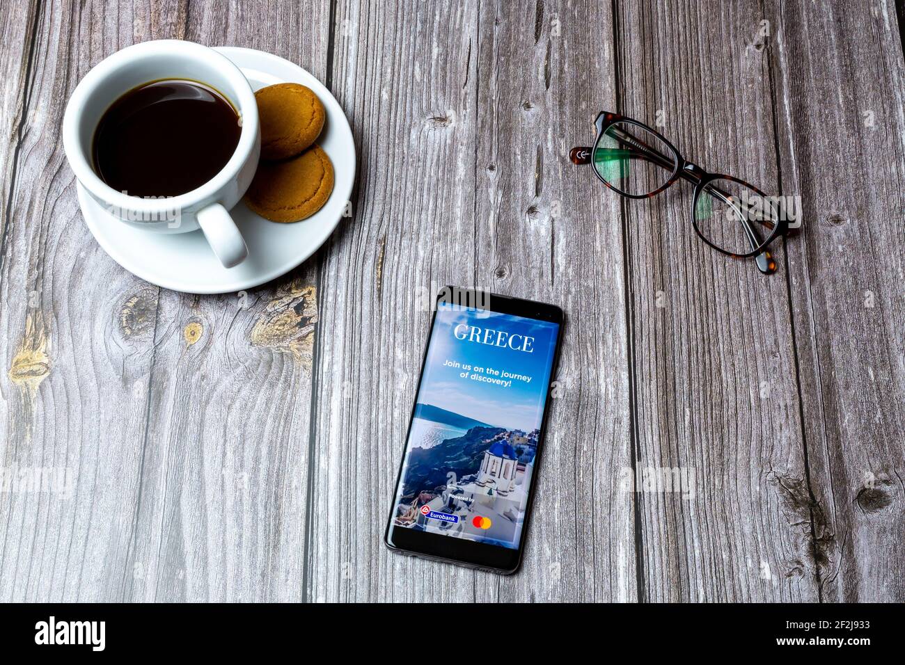 Ein Handy oder Handy auf einem Holz gelegt Tabelle mit der Visit Greece App auf dem Bildschirm geöffnet Stockfoto