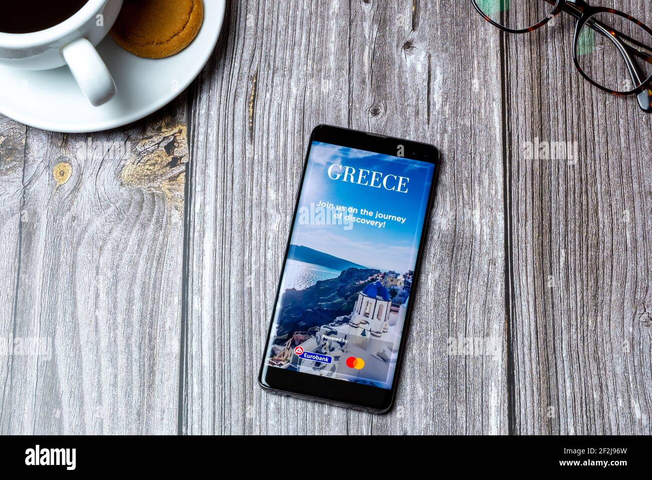 Ein Handy oder Handy auf einem Holz gelegt Tabelle mit der Visit Greece App auf dem Bildschirm geöffnet Stockfoto