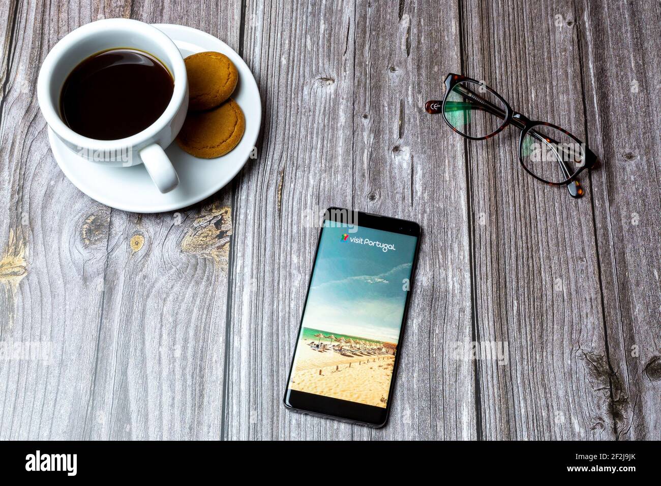 Ein Handy oder Handy auf einem Holz gelegt Tabelle mit der Visit Portugal App auf dem Bildschirm geöffnet Stockfoto