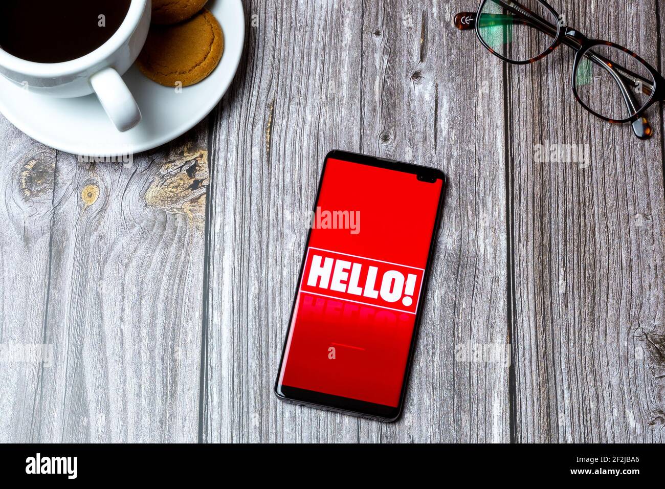 Ein Handy oder Handy auf einem Holz gelegt Tabelle mit der Hello Magazine App auf dem Bildschirm geöffnet Stockfoto