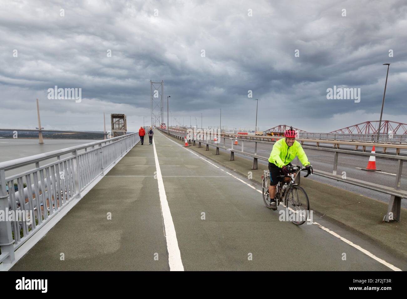 Ein Radfahrer, der mit dem Fahrrad über die Forth Road Bridge, Firth of Forth, Schottland, Großbritannien, fährt Stockfoto