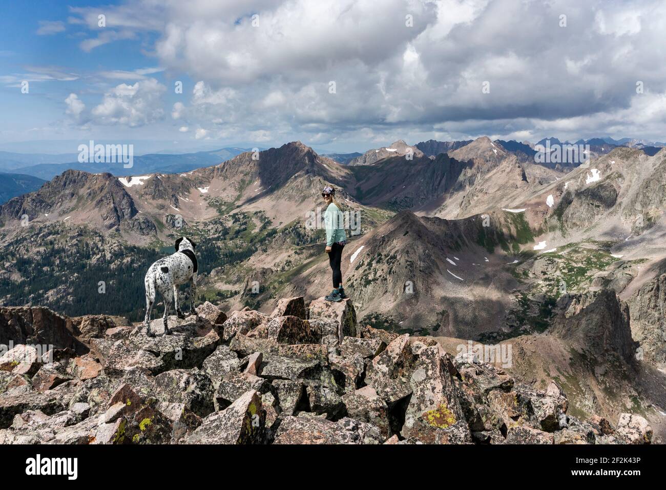Seitenansicht der Wanderweibchen beim Wandern mit Hund auf dem Berg Es weht schwacher bewölktes Wetter Stockfoto