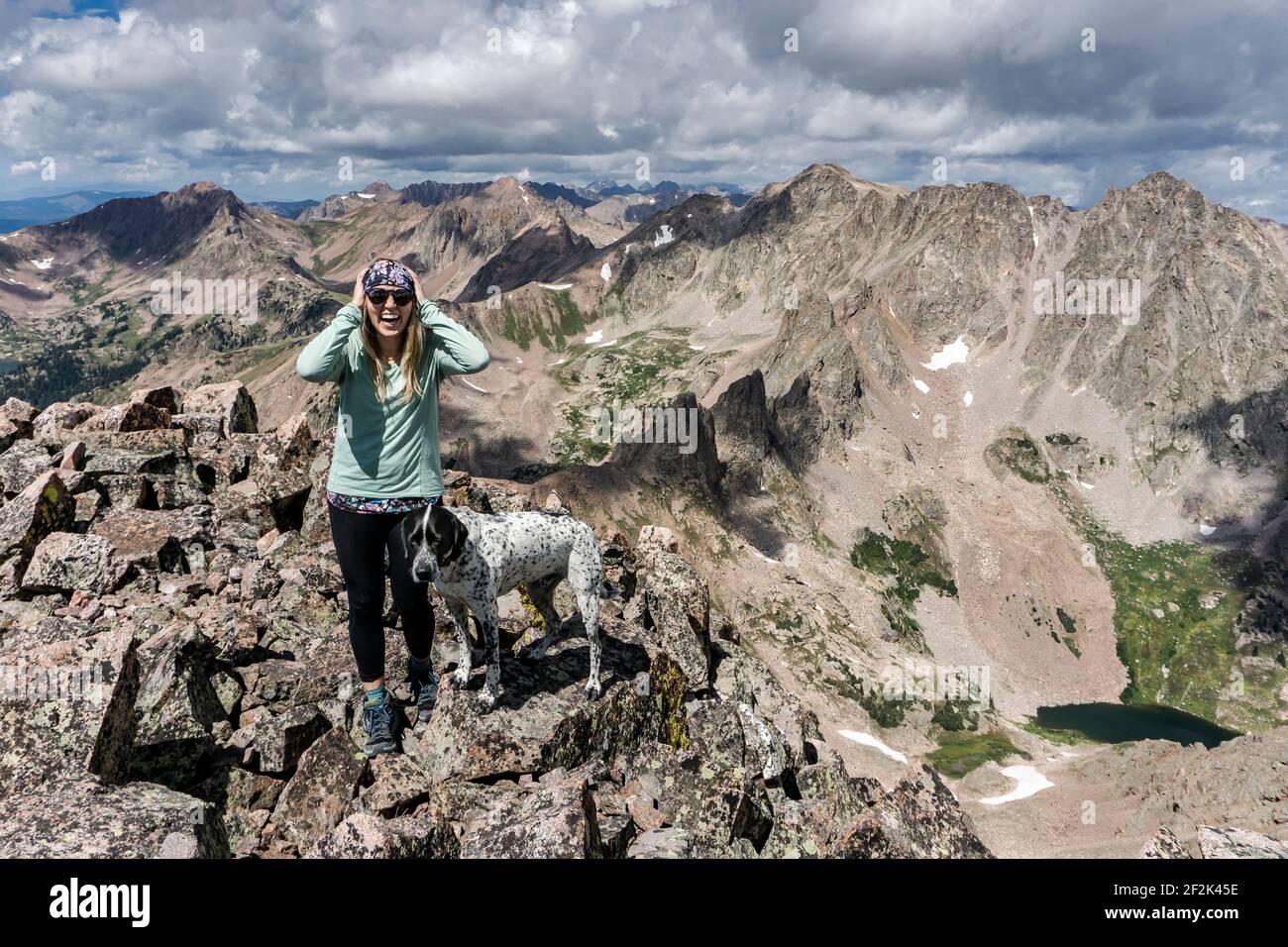 Glückliche Hündin Wandern mit Hund auf Berg gegen bewölkt Himmel Stockfoto