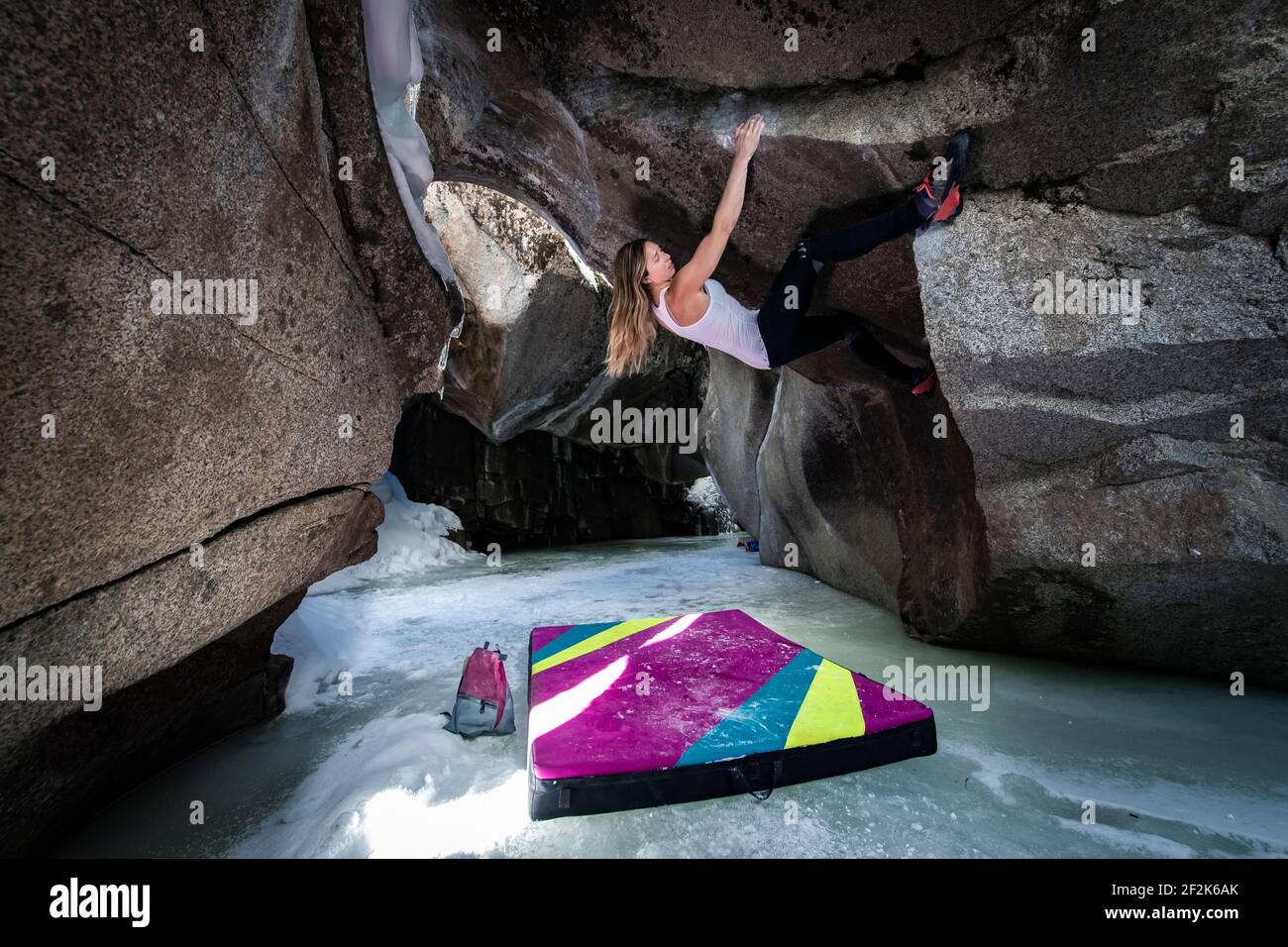 Entschlossene junge Frau beim Bouldern in Eishöhlen am Independence Pass Stockfoto