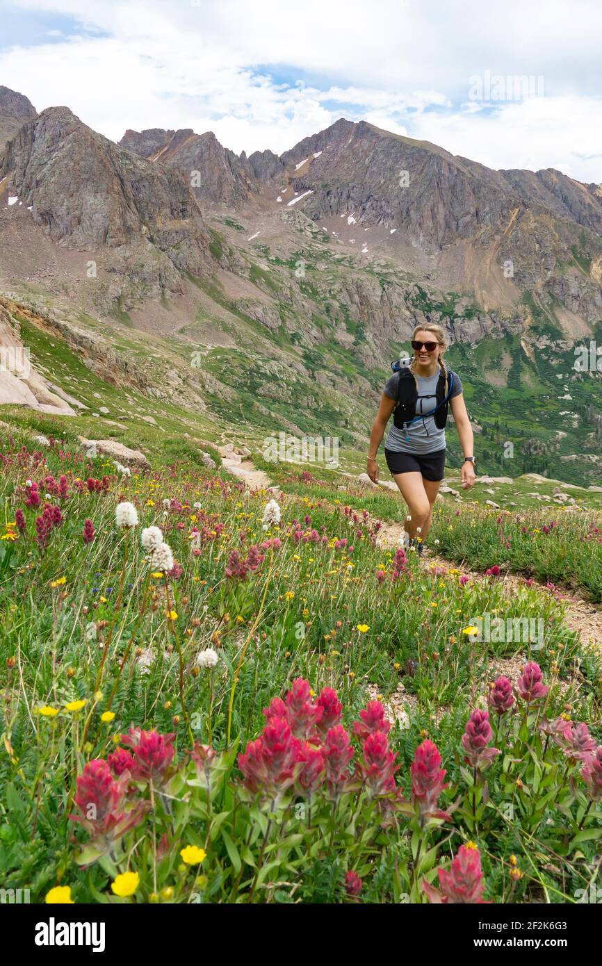 Lächelnde junge Frau, die im Urlaub auf dem Berg wandert Stockfoto
