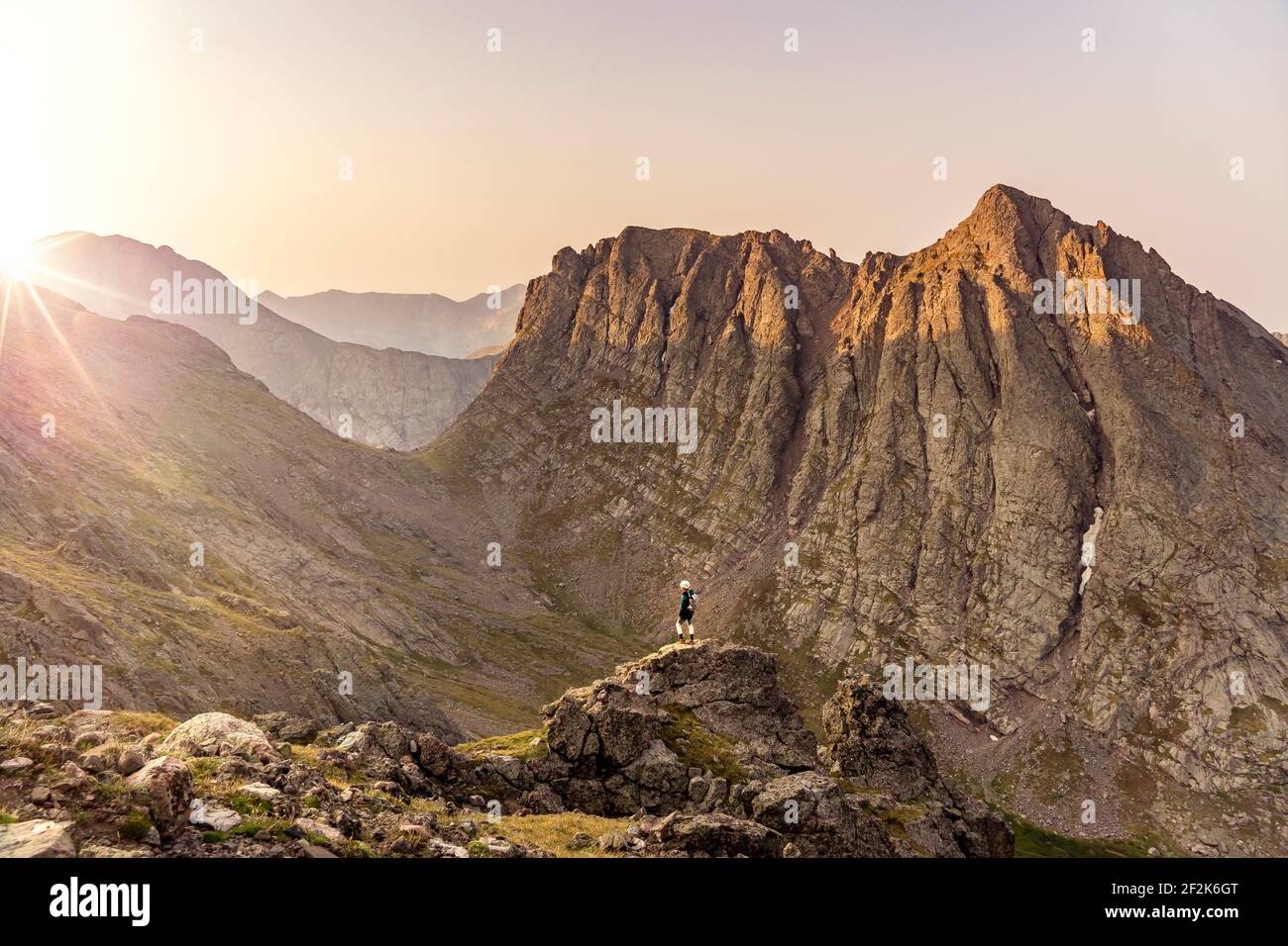 Frau mit Blick auf die Aussicht, während sie auf dem Gipfel des Berges steht Gegen klaren Himmel bei Sonnenuntergang Stockfoto