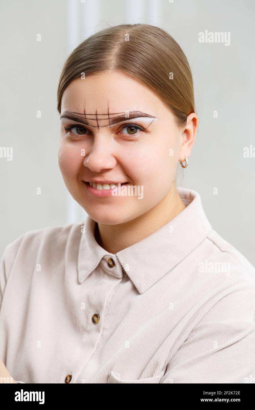 Makeup Artist wendet Augenbrauentönung für die dauerhafte Make-up eines jungen Mädchens. Professionelles Make-up und kosmetische Gesichtspflege Stockfoto