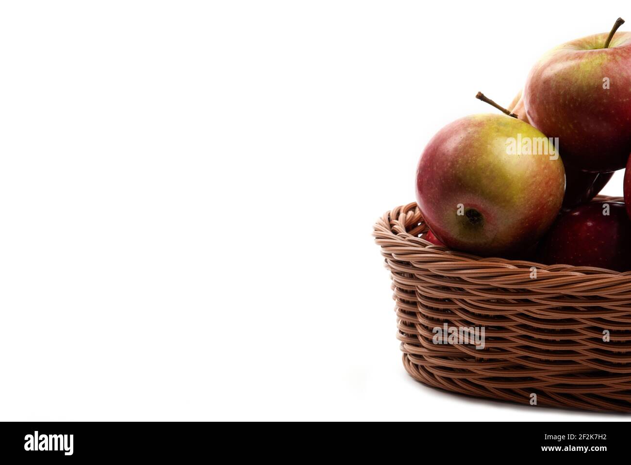 Korbkorb mit frischen saftigen Äpfeln isoliert auf weißem Hintergrund Stockfoto