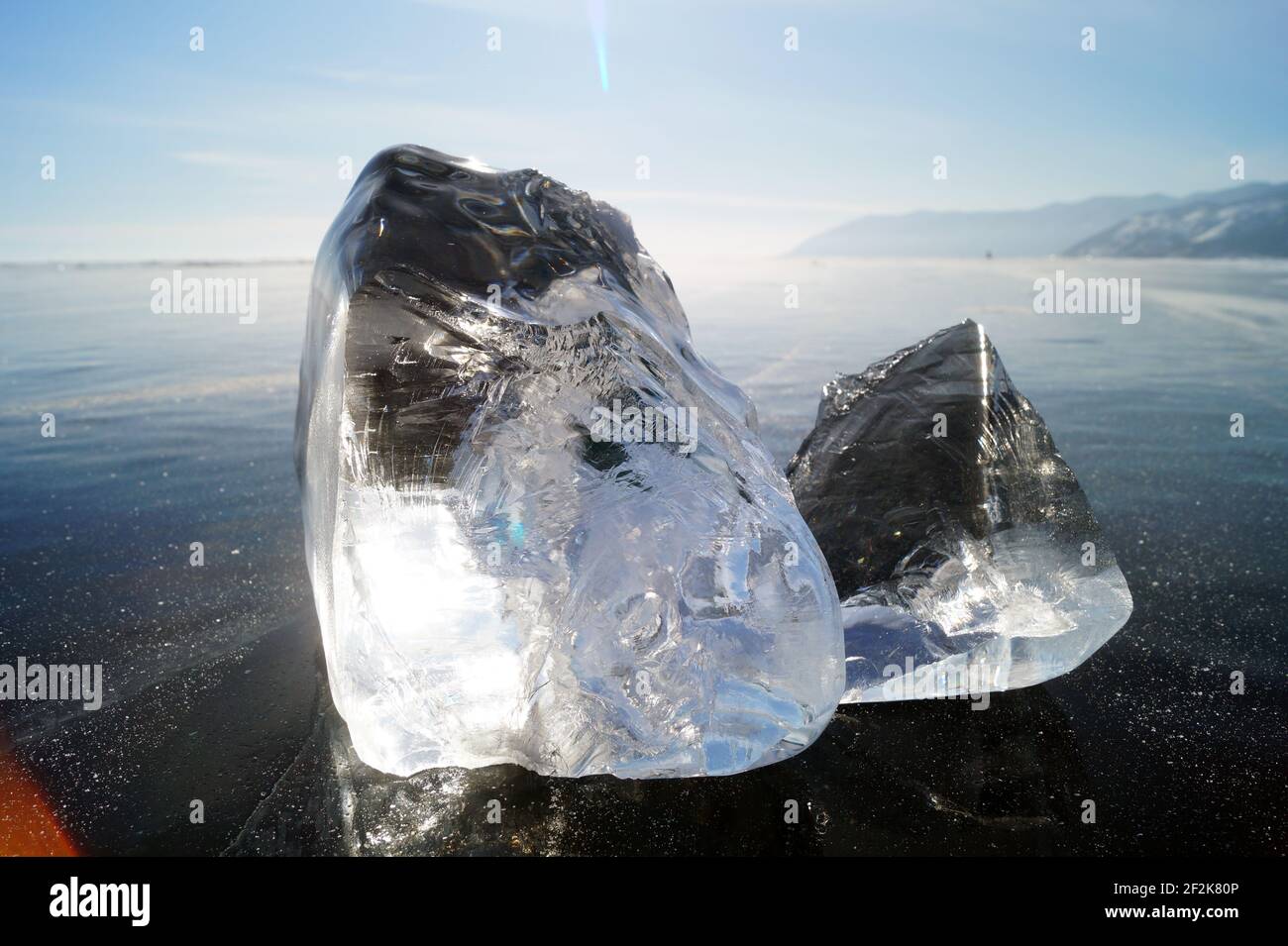Zwei Eisstücke liegen auf dem glatten, transparenten Eis Des Baik-Sees Stockfoto