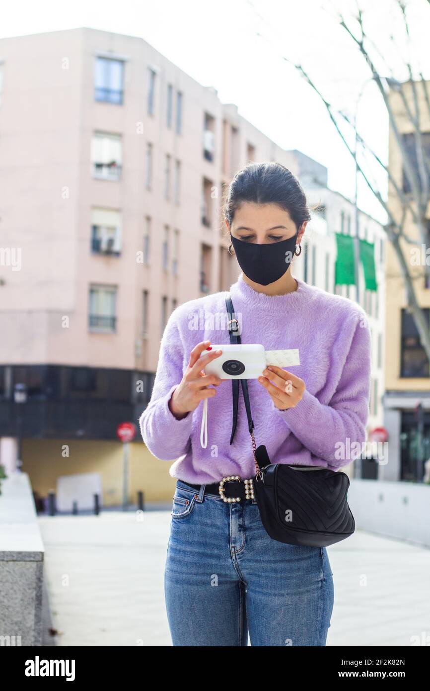 Junge Frau mit Fotodrucker auf der Straße Stockfoto