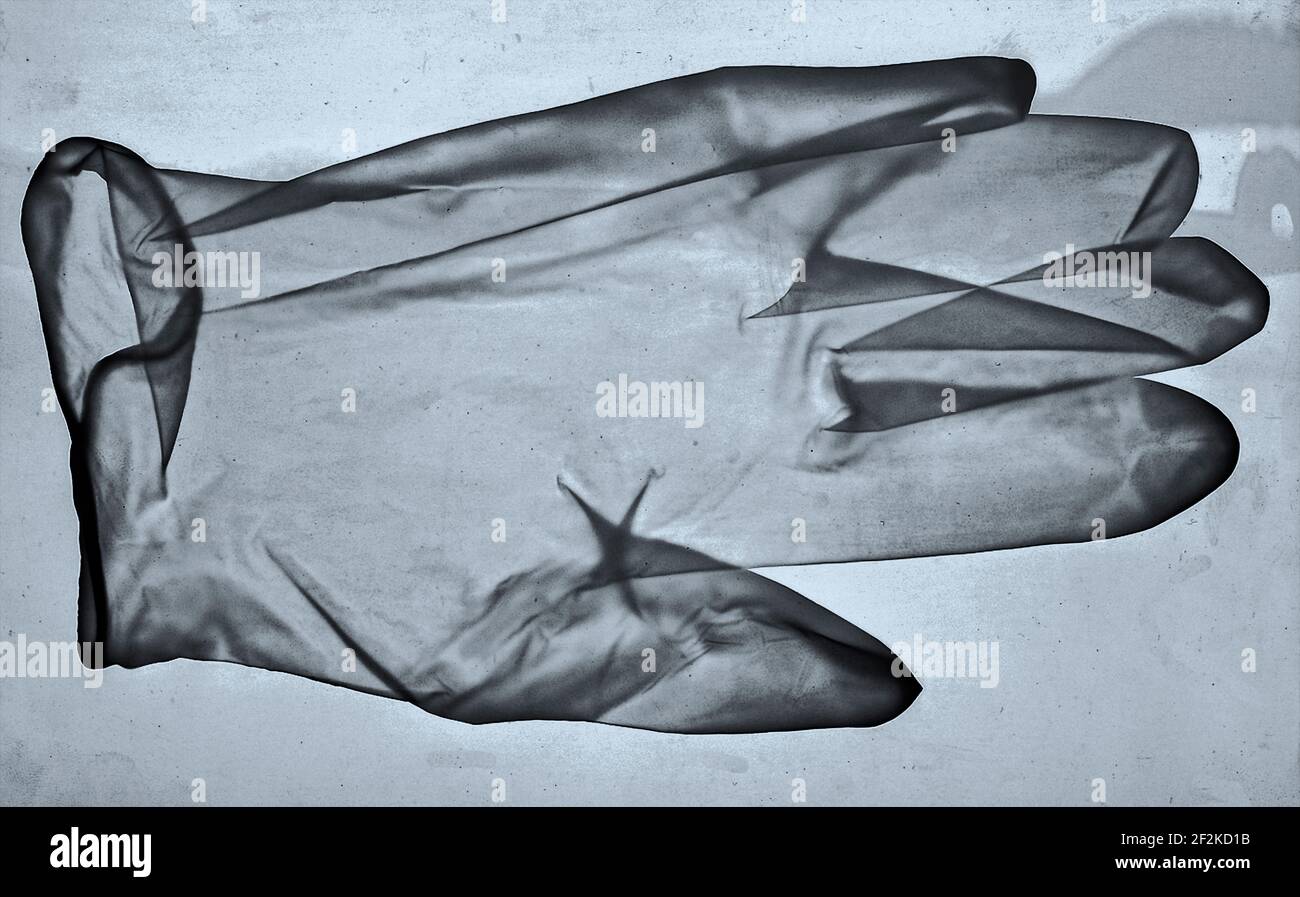 Medizinischer Latex Einweghandschuh als Röntgenbild mit möglichen Viren, Verunreinigungen und Partikeln. Stockfoto