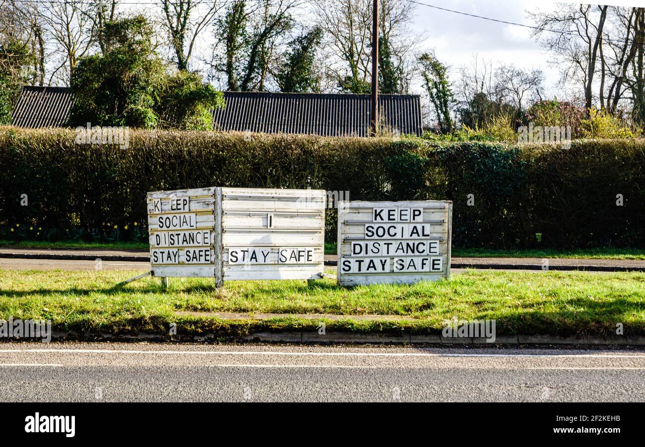 „Halten Sie soziale Distanz“, „bleiben Sie sicher“, Straßenschilder in Tiddlington, Oxfordshire, Großbritannien. Coronavirus-Pandemie. Stockfoto