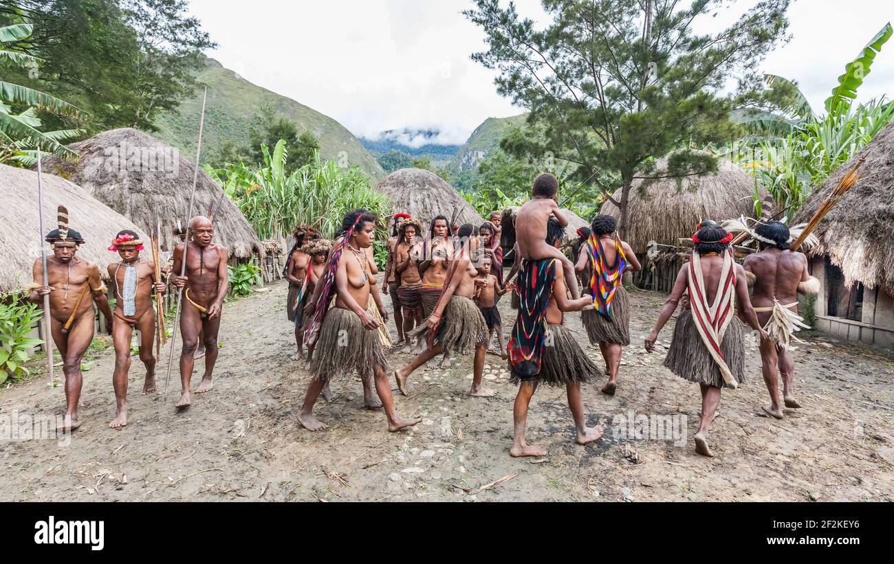 Wamena, Indonesien - 9. Januar 2010: Menschen des Dani-Stammes in traditionellen Kleidern tanzen im Dorf. Stockfoto
