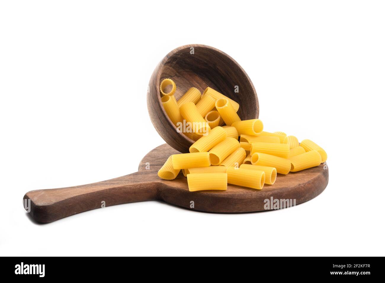 Holzschüssel voll von ungekochten glatten kurzen Röhren Form Pasta Auf einem Holzbrett Stockfoto
