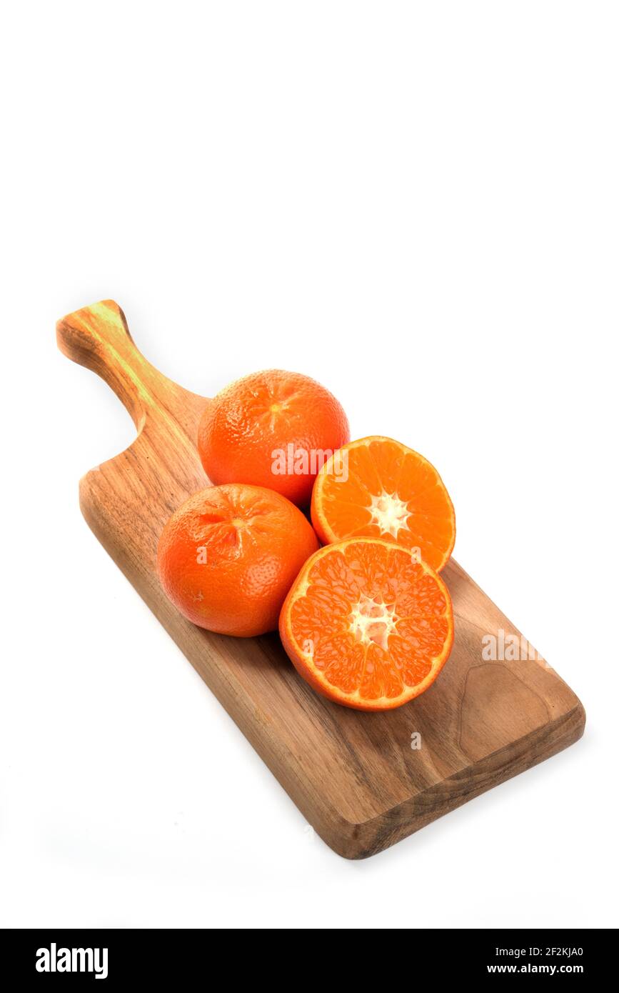 Ganze und schneiden saftige frische Orangenfrüchte auf einem Holz Schneidebrett Stockfoto