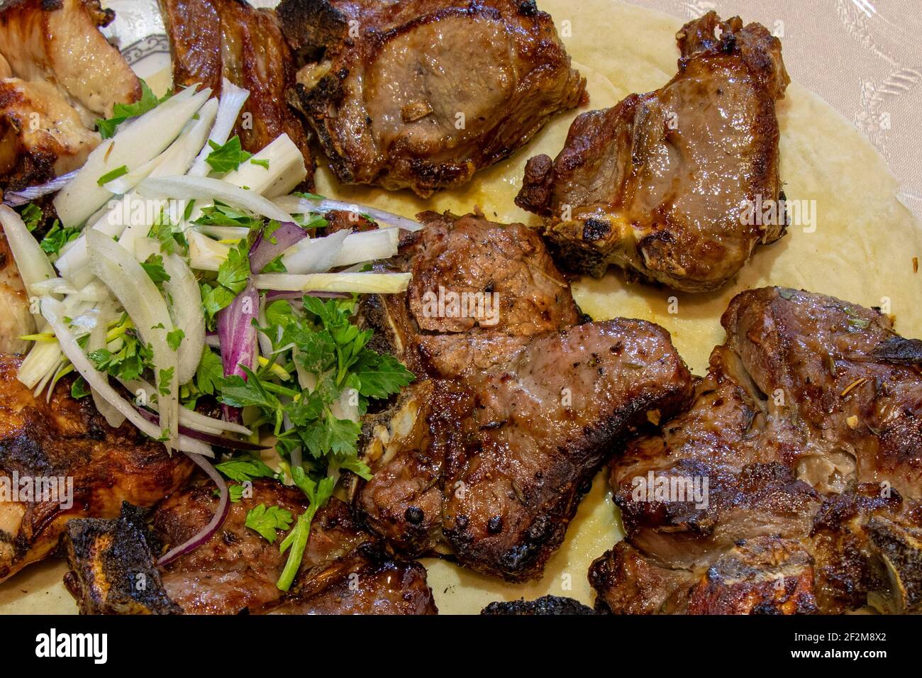 Gegrillter Fleischshashlik mit Gewürzen. Der kaukasische Schischkebab. Saftiges gegrilltes Rindfleisch auf einem Teller Stockfoto