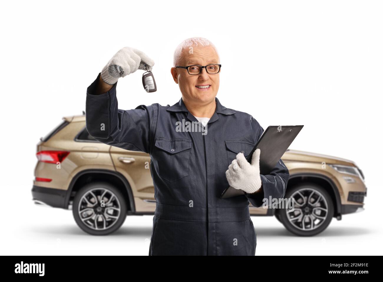 Auto Mechaniker hält einen Schlüssel und posiert mit einem SUV Isoliert auf weißem Hintergrund Stockfoto