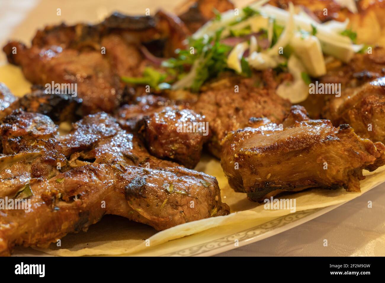 Gegrillter Fleischshashlik mit Gewürzen. Der kaukasische Schischkebab. Saftiges gegrilltes Rindfleisch auf einem Teller Stockfoto