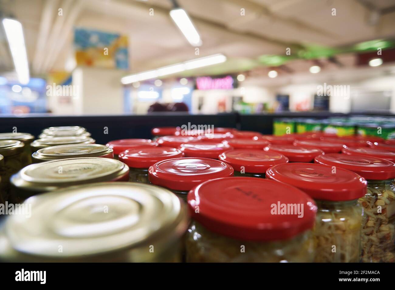 Perspektivischer Blick in einen Supermarkt über Glaskonserven auf der Supermarkt Regal Stockfoto