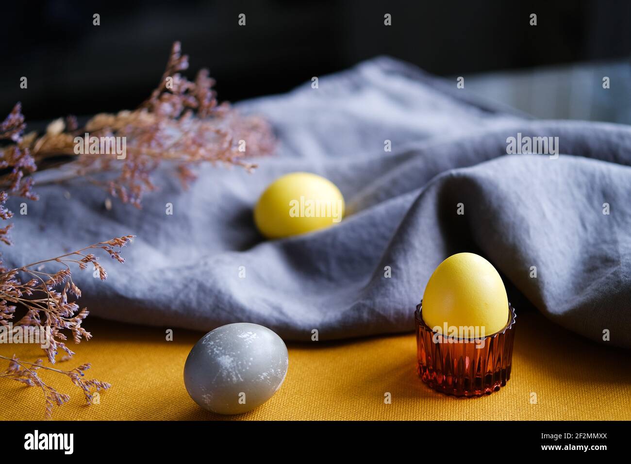 Bio natürlich gefärbte gelbe und graue Ostereier. Stockfoto