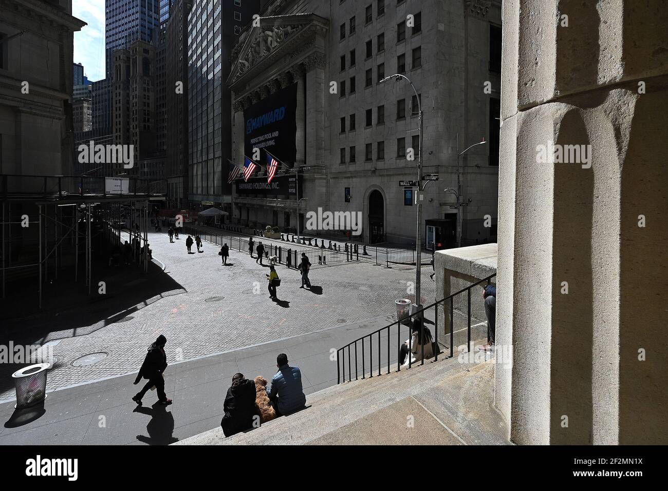 New York, USA. März 2021, 12th. Menschen sitzen auf den Stufen der Federal Hall gegenüber der New Yorker Börse in New York, NY, 12. März 2021. Präsident Biden hat gestern ein $1,9 Billionen COVID-19-Hilfspreispaket in Kraft gesetzt, nachdem es den Kongress genehmigt hatte. (Foto von Anthony Behar/Sipa USA) Quelle: SIPA USA/Alamy Live News Stockfoto
