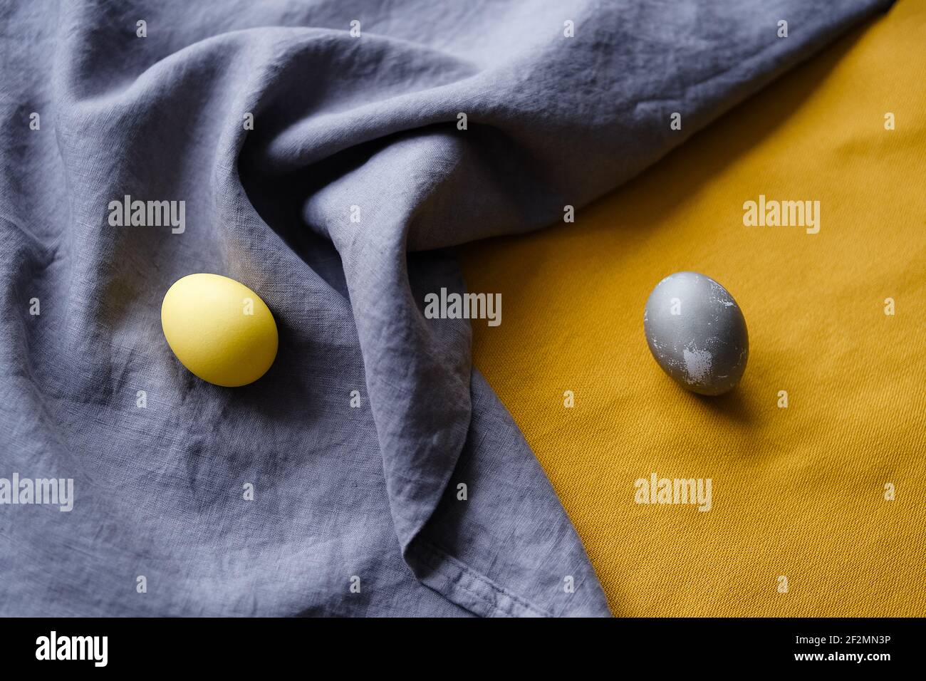 Bio natürlich gefärbte gelbe und graue Ostereier. Stockfoto