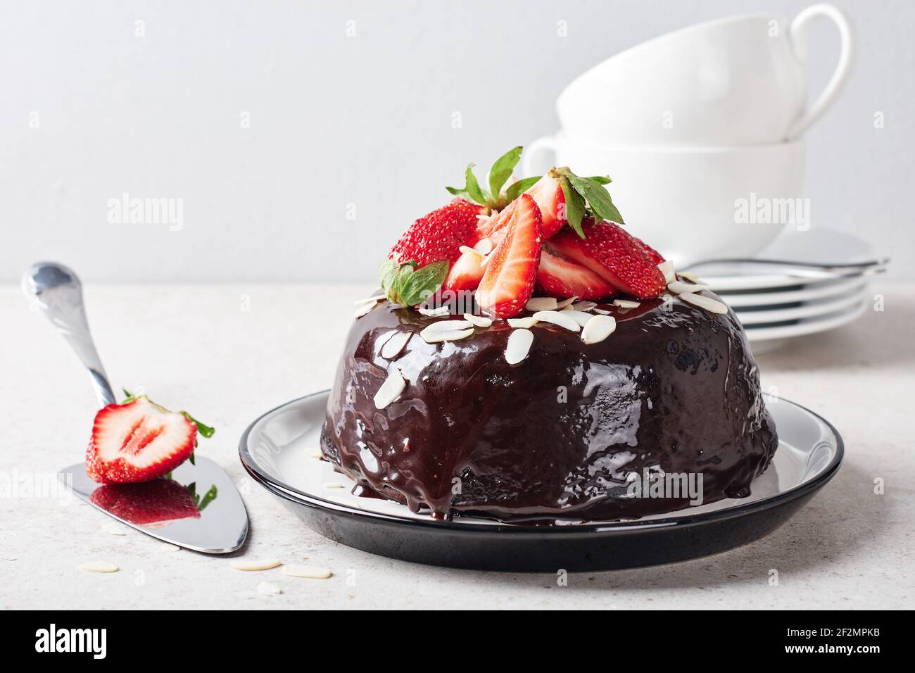 Schokoladenkuchen mit frischen Erdbeeren und Mandelflocken. Stockfoto