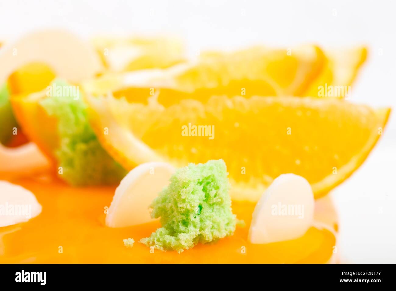 Kiwi Siphon Schwamm auf orange glasierte Kuchen. Makro. Foto kann als ganzer Hintergrund verwendet werden. Stockfoto