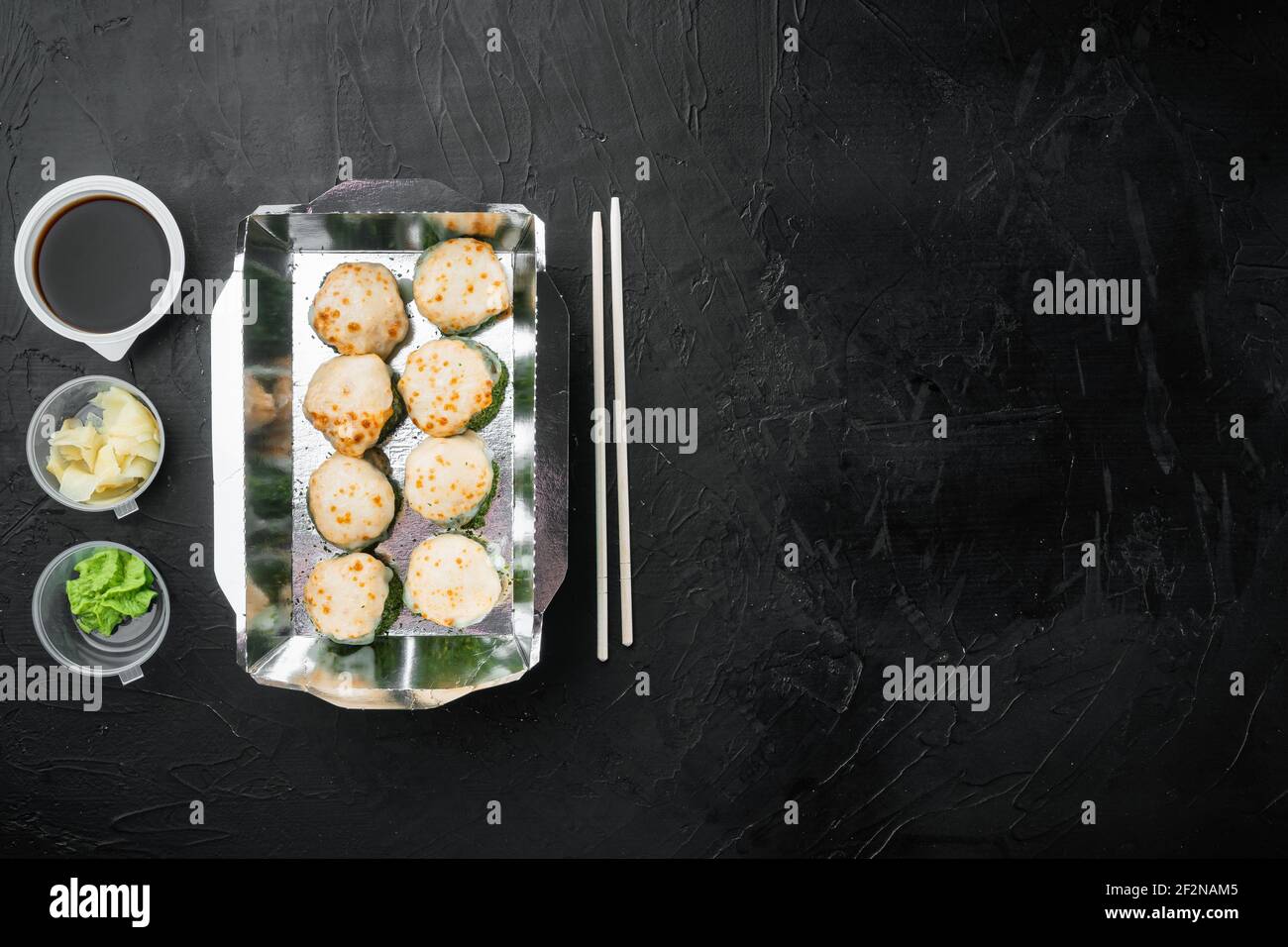 Sushi Roll Delivery Set, auf schwarzem Stein Hintergrund, Draufsicht flach legen, mit Copyspace und Platz für Text Stockfoto