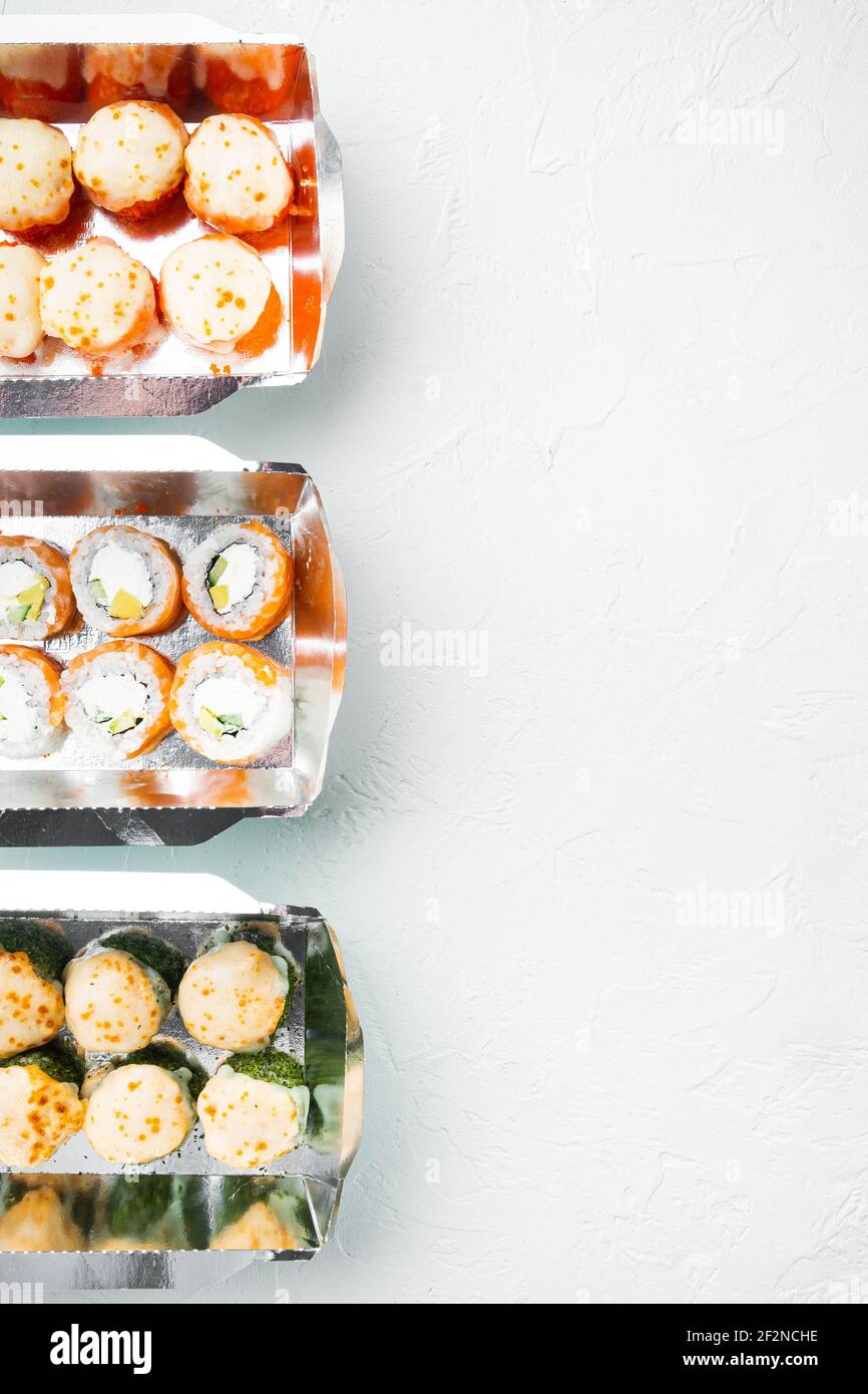 Vielfalt an verschiedenen Sushi und Brötchen für, Lachs und Thunfisch in Lieferung Food-Konzept-Set, auf weißem Stein Hintergrund, Draufsicht flach Lay, mit Copyspace Stockfoto