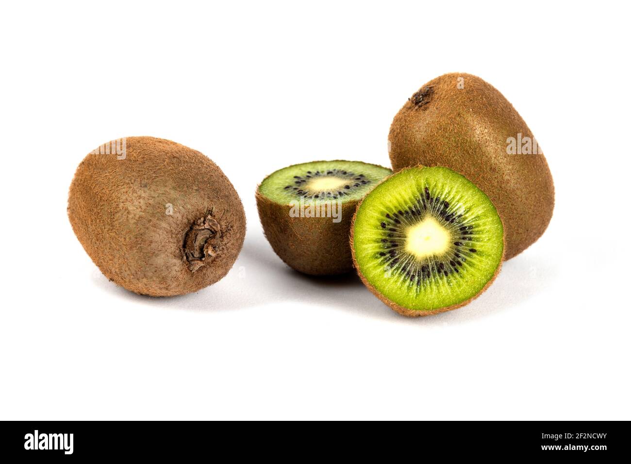Ganze Kiwi-Früchte und halbe Kiwi-Früchte auf einem weißen Hintergrund Stockfoto