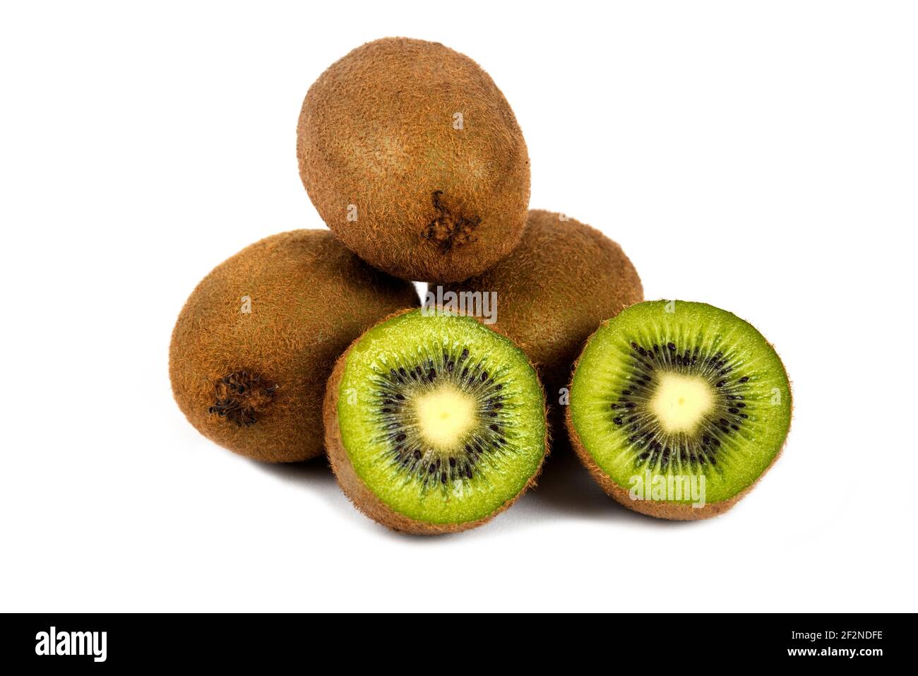 Ganze Kiwi-Früchte und halbe Kiwi-Früchte auf einem weißen Hintergrund Stockfoto