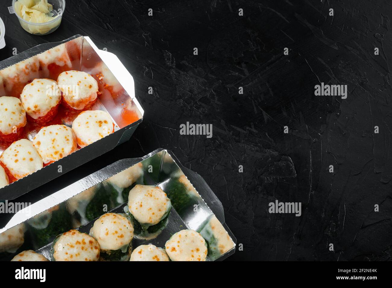 Japanisches Speisekonzept. Catering, verschiedene Arten von Sushi philadelphia Brötchen und gebackene Garnelen Rollen Set, auf schwarzem Stein Hintergrund, mit Copyspace und s Stockfoto