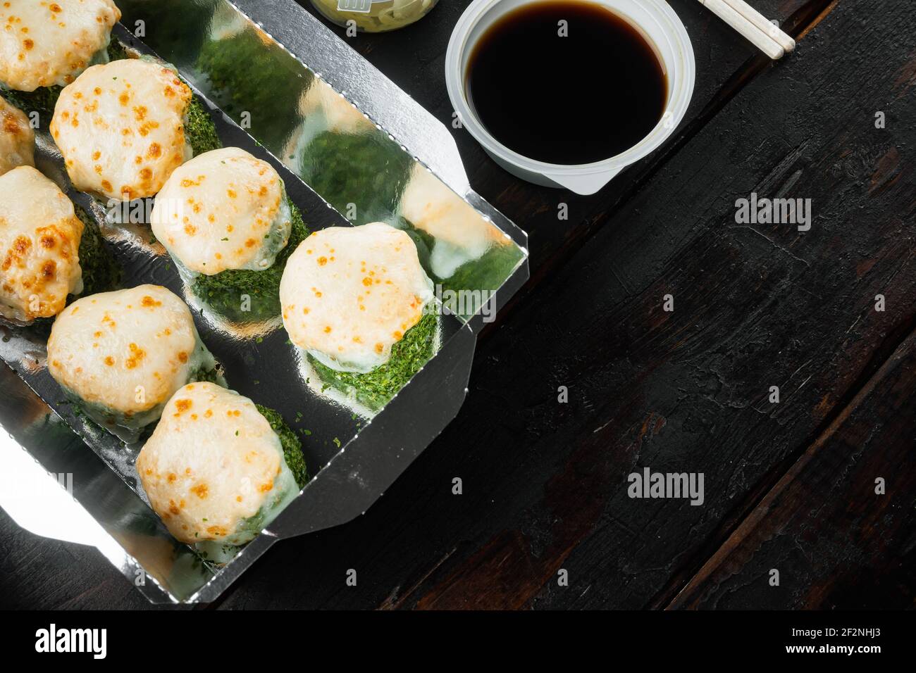 Japanisches Speisekonzept. Catering, verschiedene Arten von Sushi philadelphia Brötchen und gebackene Garnelen Rollen Set, auf alten dunklen Holztisch Hintergrund, mit Kopys Stockfoto