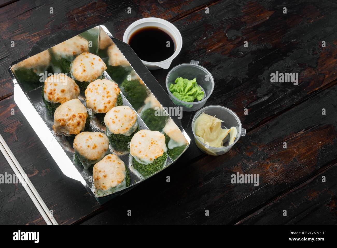 Set von Sushi-Rollen in Lieferung Food-Box-Set, auf alten dunklen Holztisch Hintergrund, mit Copyspace und Platz für Text Stockfoto