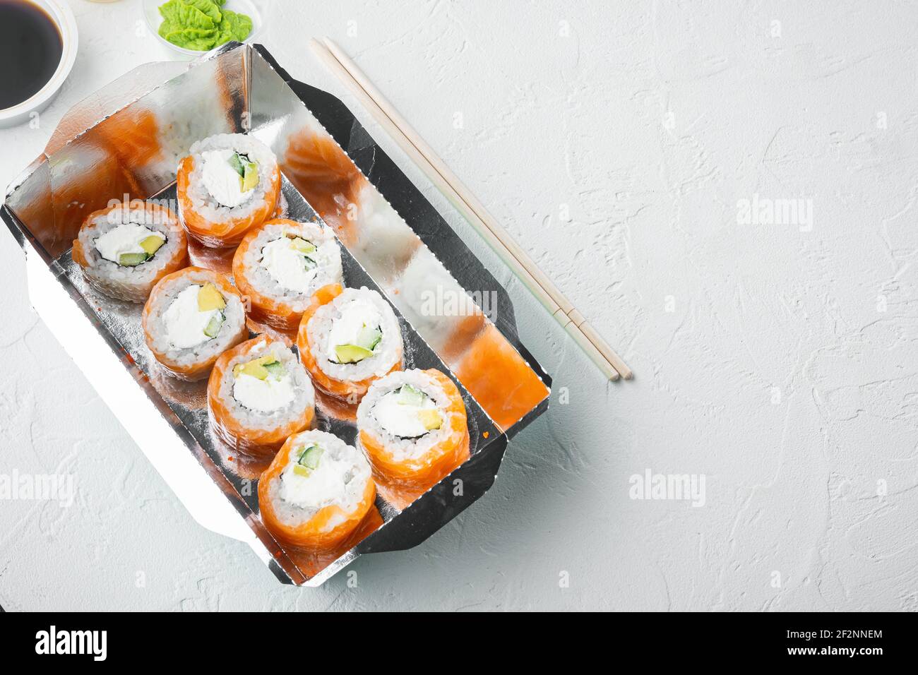 Japanisches Speisekonzept. Catering, verschiedene Arten von Sushi philadelphia Brötchen und gebackene Garnelen Rollen Set, auf weißem Stein Hintergrund, mit Copyspace und s Stockfoto