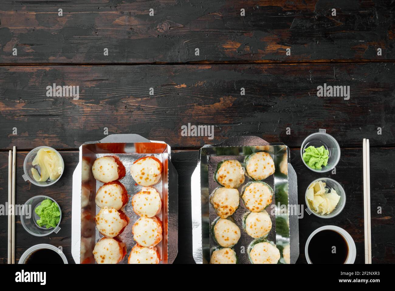 Japanisches Speisekonzept. Catering, verschiedene Arten von Sushi philadelphia Brötchen und gebackene Garnelen Rollen Set, auf alten dunklen Holztisch Hintergrund, Draufsicht fl Stockfoto