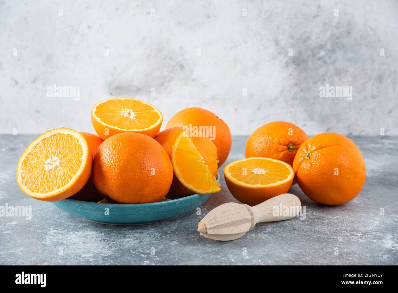 Ein Teller voller geschnittener und voller saftiger Orangenfrüchte Mit Holzreimer Stockfoto