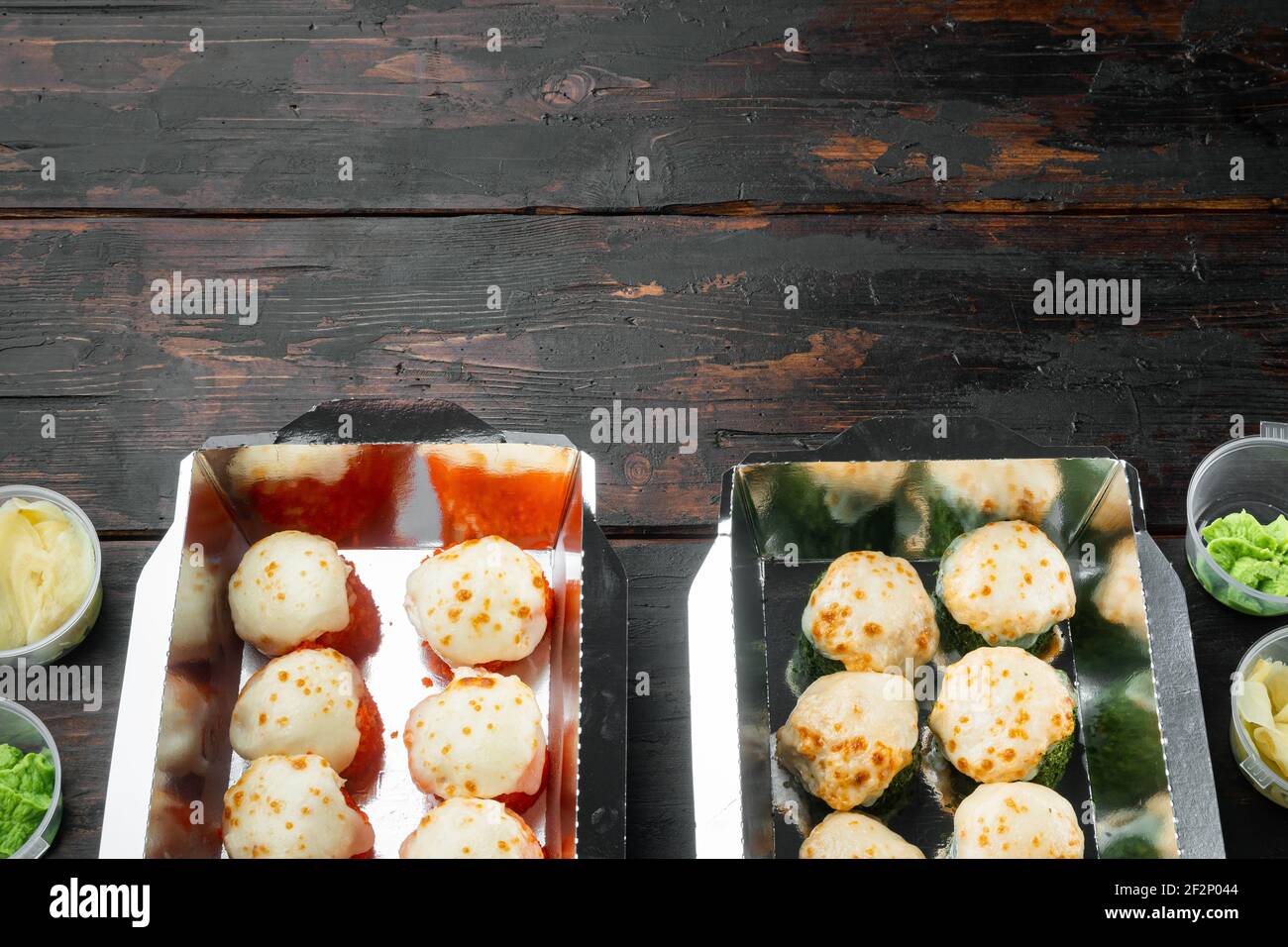 Sushi-Rollen im Takeaway-Container-Set, auf altem dunklen Holztischhintergrund, mit Copyspace und Platz für Text Stockfoto
