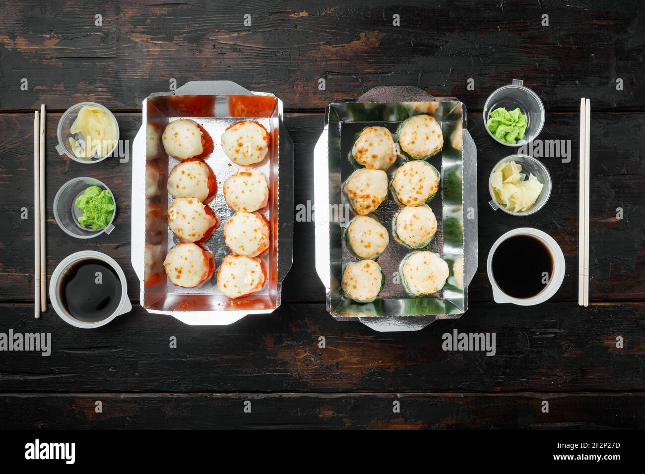 Leckere Sushi-Rollen in Einwegboxen Set, auf alten dunklen Holztisch Hintergrund, Draufsicht flach legen, mit Copyspace und Platz für Text Stockfoto