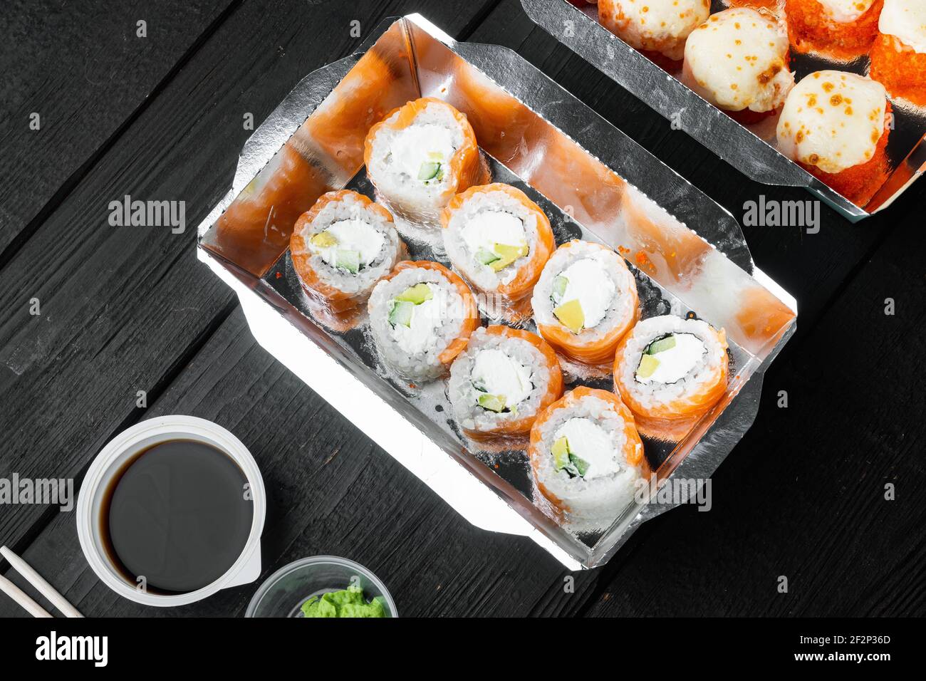Sushi Roll Delivery Set, auf schwarzem Holztisch Hintergrund, mit Copyspace und Platz für Text Stockfoto