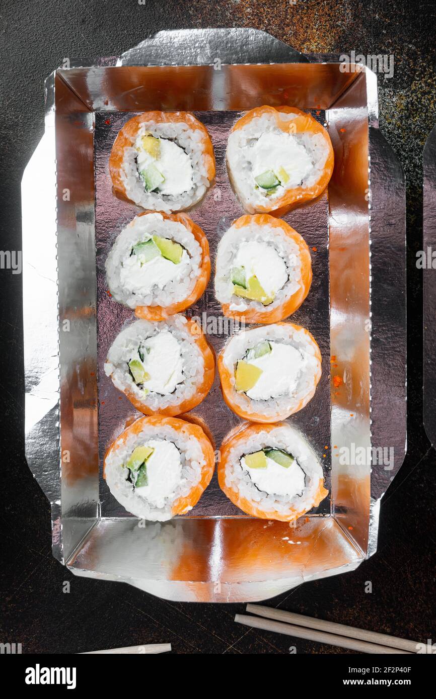 Japanisches Speisekonzept. Catering, verschiedene Arten von Sushi philadelphia Brötchen und gebackene Garnelen Brötchen Set, auf alten dunklen rustikalen Hintergrund, Draufsicht flach Lay Stockfoto
