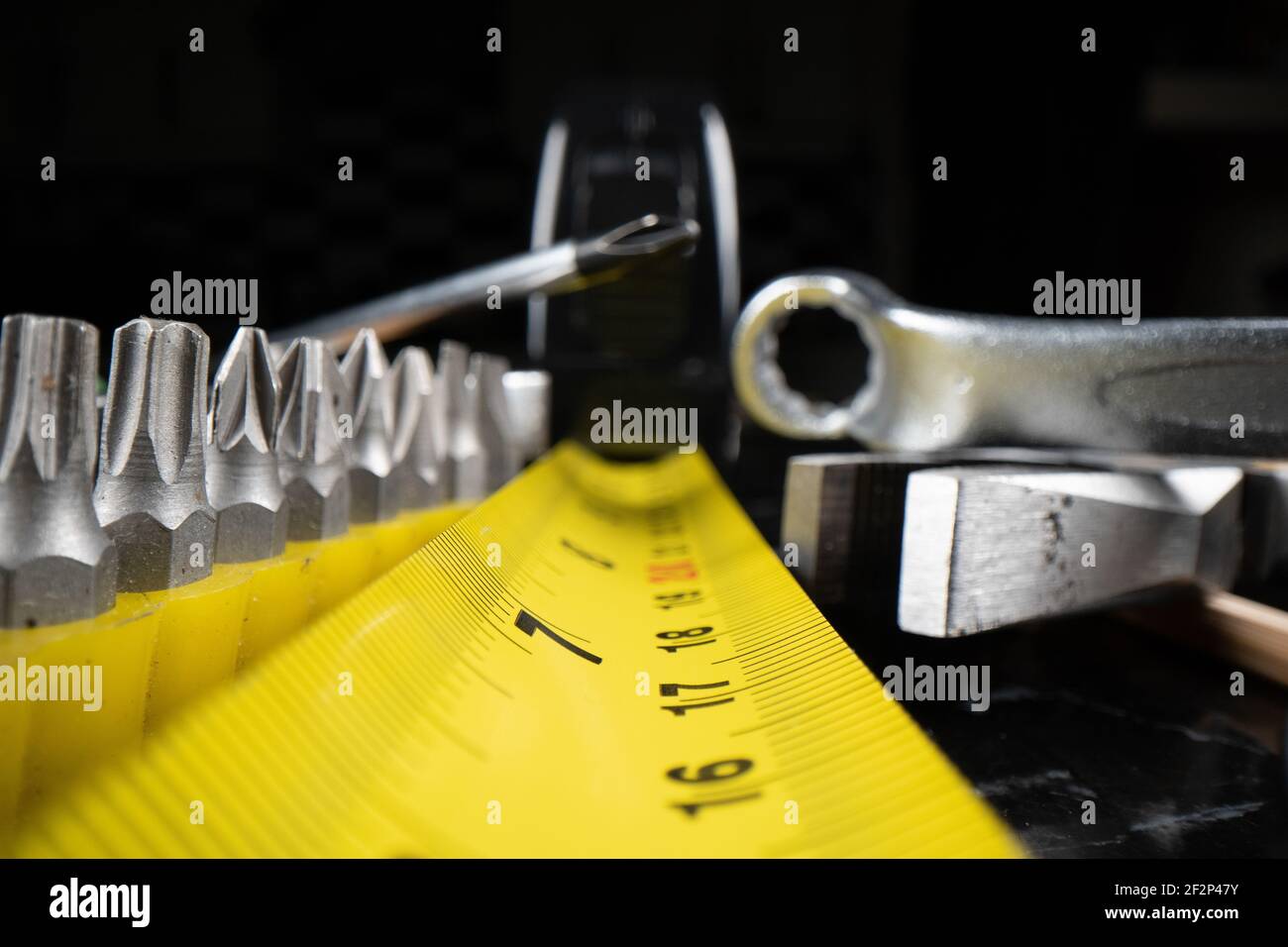 Makro-Aufnahme mit niedrigem Winkel von Maßband und Werkzeugen, die mit einem Laowa 24mm Sondenobjektiv aufgenommen wurden. Stockfoto