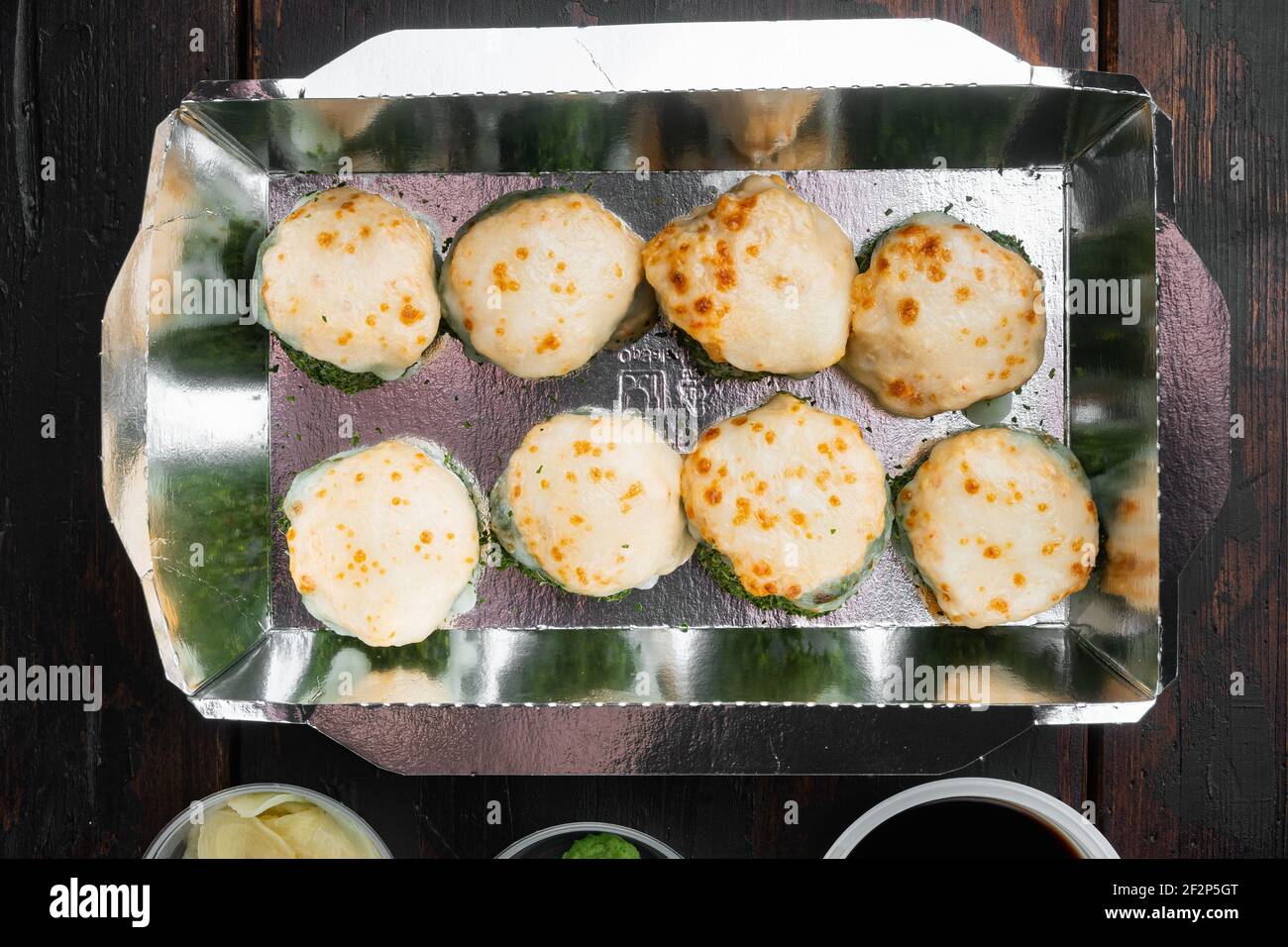 Leckere Sushi-Rollen in Einwegkisten Set, auf alten dunklen Holztisch Hintergrund, Draufsicht flach legen Stockfoto