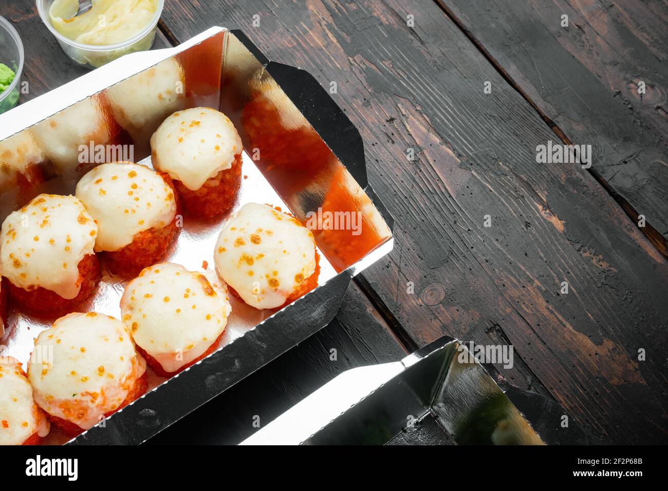 Vielfalt an verschiedenen Sushi und Rollen, Lachs und Thunfisch in Lieferung Food-Konzept-Set, auf alten dunklen Holztisch Hintergrund, mit Copyspace und Platz Stockfoto