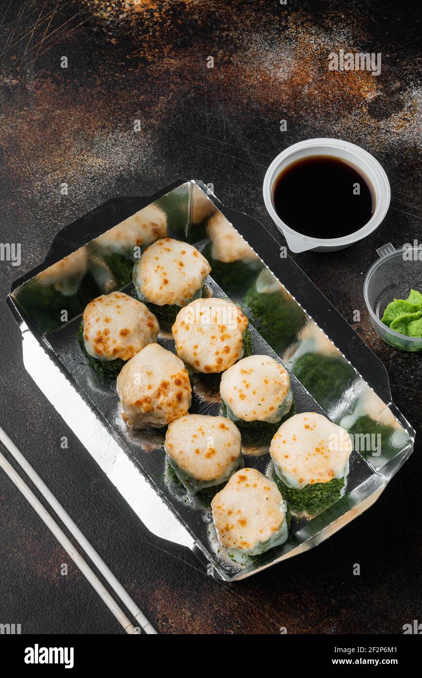 Leckere Sushi-Rollen in Einwegboxen Set, auf altem dunklen rustikalen Hintergrund, mit Copyspace und Platz für Text Stockfoto