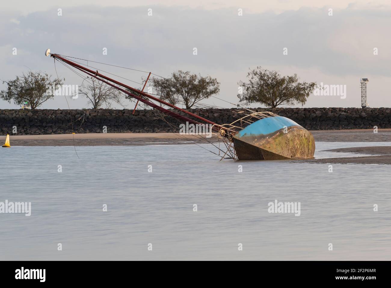Ein verlassenes Boot liegt bei Ebbe auf seiner Seite Im Hafen Stockfoto