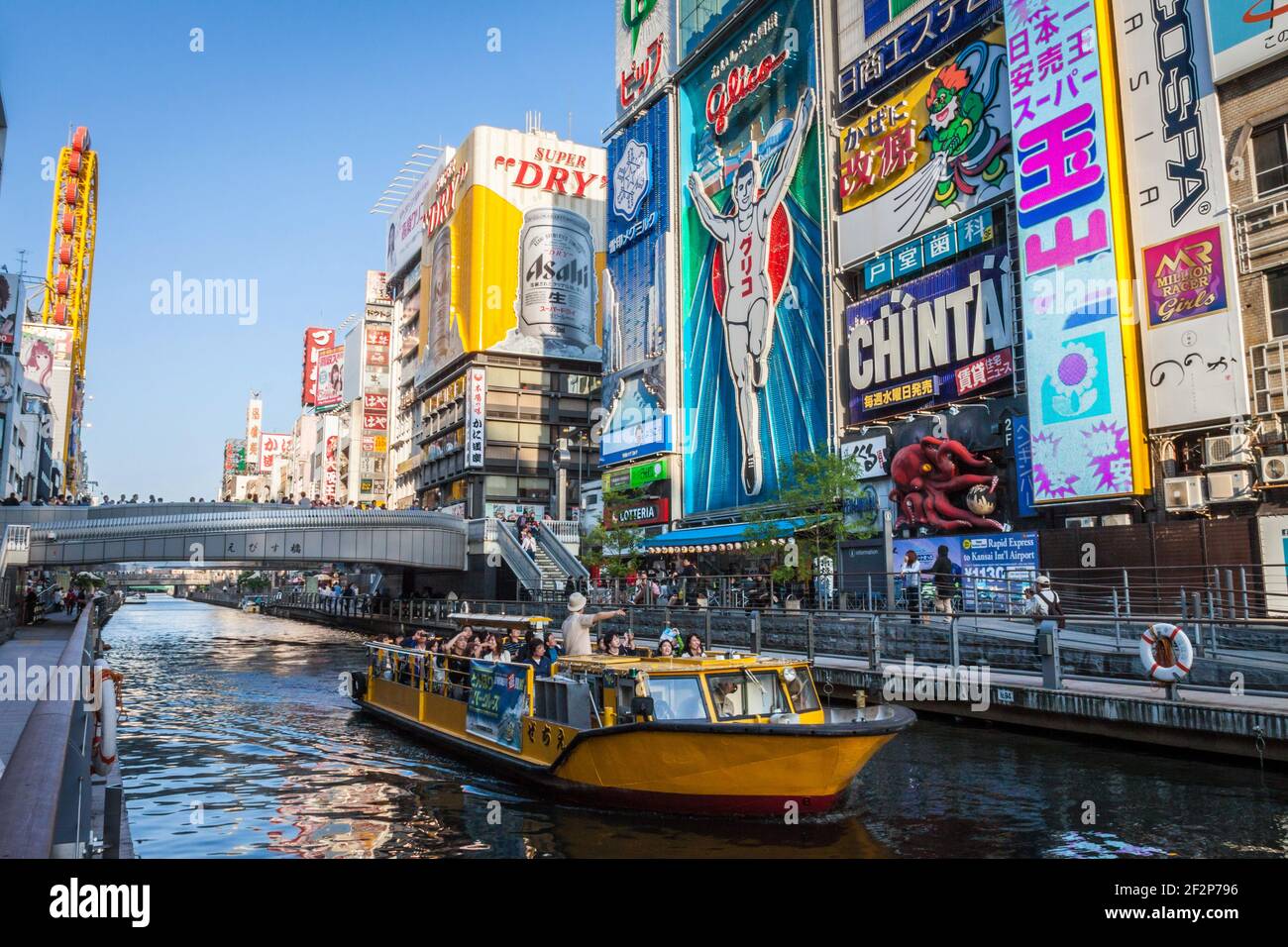 Ein Touristenboot, das den Dotonbori-Kanal unter den Neon-Schilder im Zentrum von Osaka, Japan, segelt Stockfoto