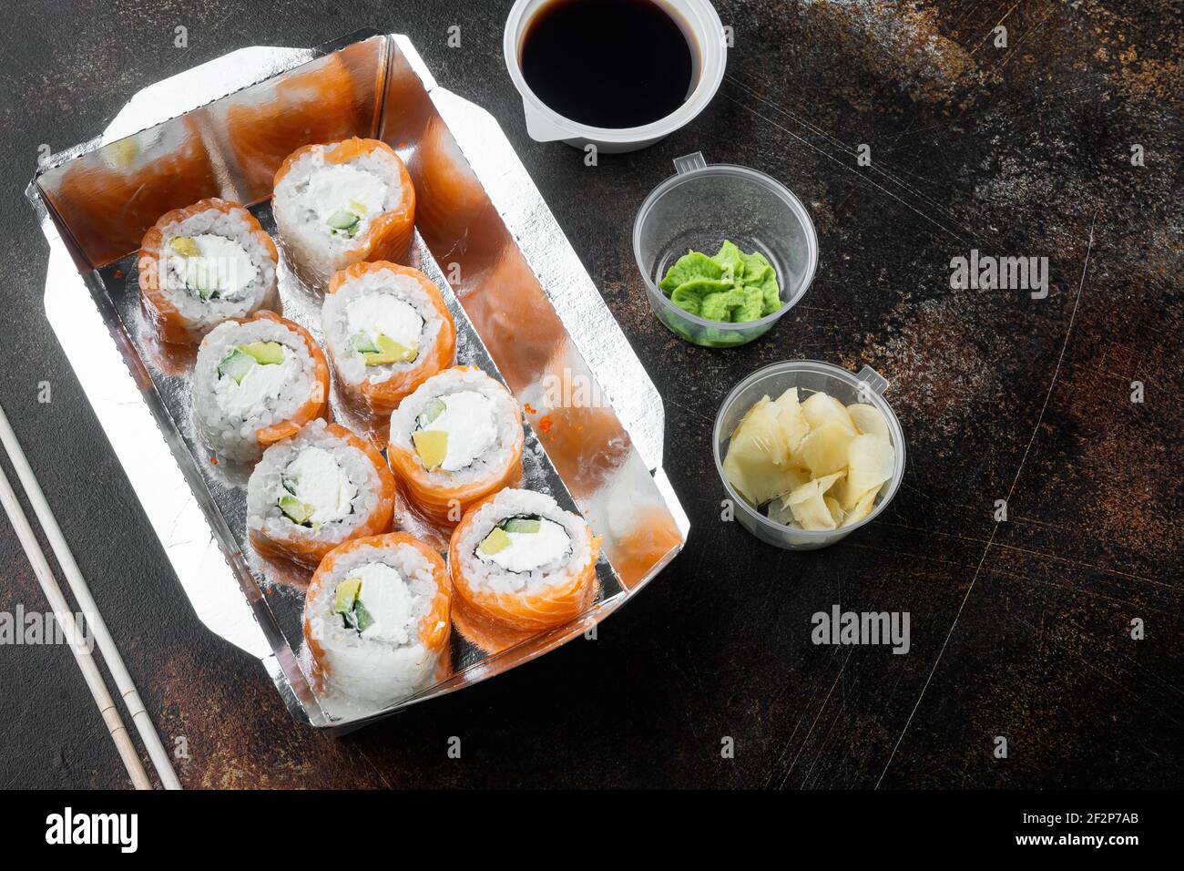 Set von Sushi-Rollen in Lieferung Food-Box-Set, auf alten dunklen rustikalen Hintergrund, mit Copyspace und Platz für Text Stockfoto