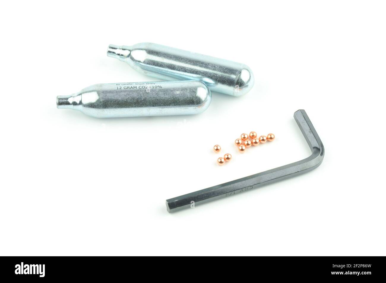CO2 Kartuschen, Pellets und Sechskantschlüssel für Luftpistole isoliert auf weißem Hintergrund. Stockfoto